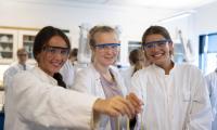Tre piger i kitler i kemilokalet