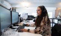 Kvindelig elev sidder ved computer og laver administrativt arbejde