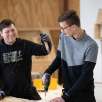 To elever i værkstedet med værktøj i hænderne